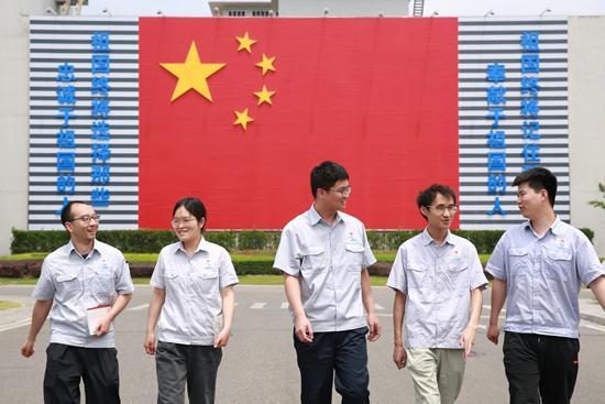 2023年，绵阳试验基地职工走过国旗墙。中国航发涡轮院供图